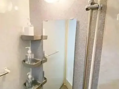 a bathroom with a shower with two shelves on the wall at \u30ec\u30ac\u30ea\u30a2\u30d2\u30eb\u30ba402 in Tokyo