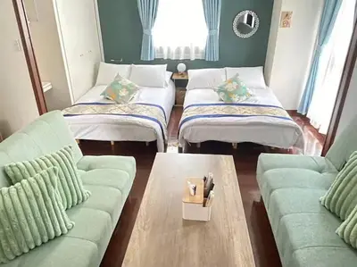 a living room with three beds and a couch at \u30ec\u30ac\u30ea\u30a2\u30d2\u30eb\u30ba402 in Tokyo
