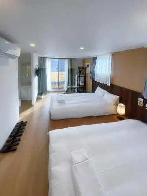 a hotel room with three beds and a large window at Softlight Inn Asakusa Tokyo in Tokyo