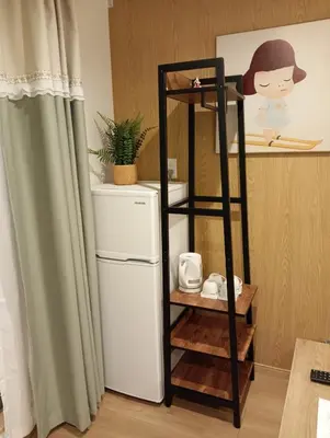 a shelf next to a refrigerator in a room at Softlight Inn Asakusa Tokyo in Tokyo