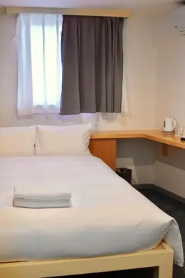a bed in a room with a window at Softlight Inn Asakusa Tokyo in Tokyo
