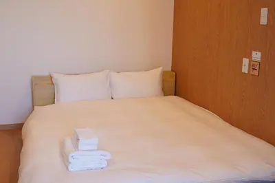 a bed with three towels sitting on top of it at Softlight Inn Asakusa Tokyo in Tokyo