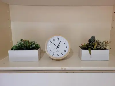 a clock on a shelf with two potted plants at Urban Stage Okubo in Tokyo