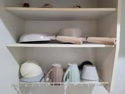 a cupboard filled with dishes and vases at Urban Stage Okubo in Tokyo