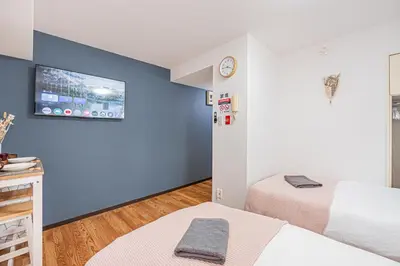 a room with two beds and a tv on the wall at \u65b0\u5bbf\u533a\u6b4c\u821e\u4f0e\u753a\u4f0a\u52bf\u4e39\u5f92\u6b653\u5206\u949f#6 in Tokyo