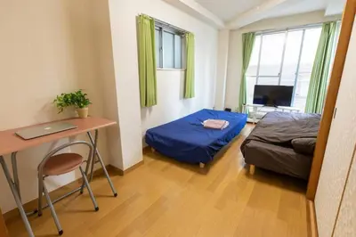a small room with a bed and a desk with a laptop at Minimalism Hotel Sumida 1 in Tokyo