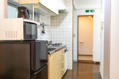 a kitchen with a microwave on top of a refrigerator at Minimalism Hotel Sumida 2 in Tokyo