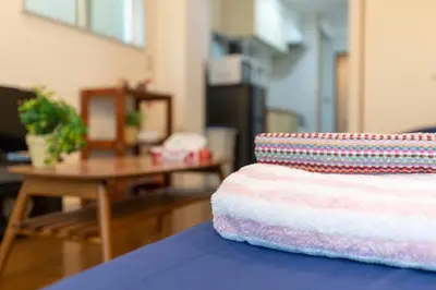 a stack of towels sitting on a table in a living room at Minimalism Hotel Sumida 2 in Tokyo