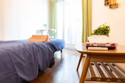 a bedroom with a bed and a table with a box of spirits at Minimalism Hotel Sumida 2 in Tokyo