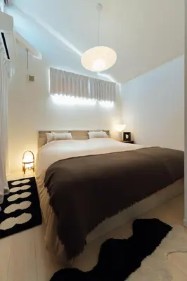 a bedroom with a large bed with a black blanket at Hotel Beswe in Tokyo