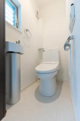 a white bathroom with a toilet and a sink at Hotel Beswe in Tokyo