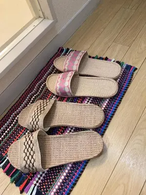 three pairs of shoes sitting on a rug next to a door at B&K Numabukuro in Tokyo