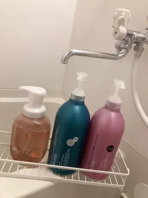 three bottles of detergents sitting in a rack in a bathroom at B&K Numabukuro in Tokyo