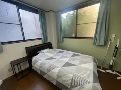 a bedroom with a bed and two windows at Tokyo Stay Nishishinjuku in Tokyo
