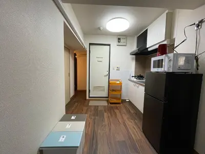 a small kitchen with a refrigerator and a microwave at JK House in Tokyo