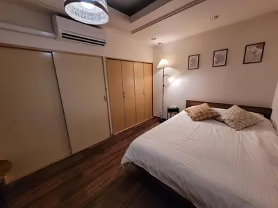 a bedroom with a large white bed and wooden floors at JK House in Tokyo