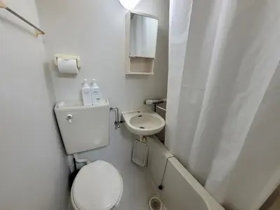 a small bathroom with a toilet and a sink at JK House in Tokyo