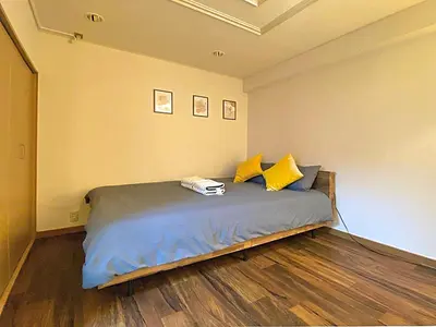 a bedroom with a bed with yellow pillows at JK House in Tokyo