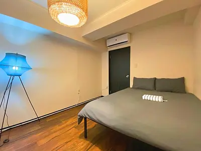 a bedroom with a bed and a blue lamp at JK House in Tokyo