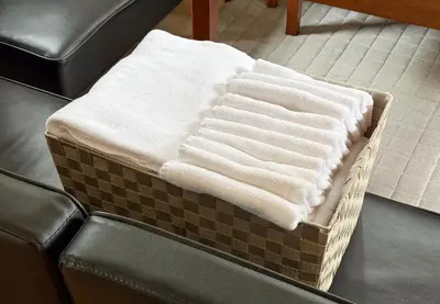 a pile of white towels sitting on top of a couch at \u4e0a\u5317\u6ca2\u6238\u5efa\u3066 in Tokyo