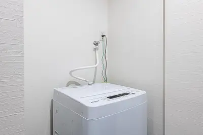 a white washing machine in a corner of a room at -Numabukuro House- 10-minute walk from Numabukuro station in Tokyo