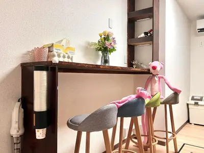 a room with two stools and a table with a shelf at ManOku in Tokyo