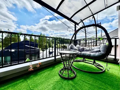 a porch with a swing and a table on a balcony at ManOku in Tokyo