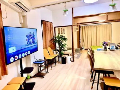 a living room with a large television on a wall at ManOku in Tokyo