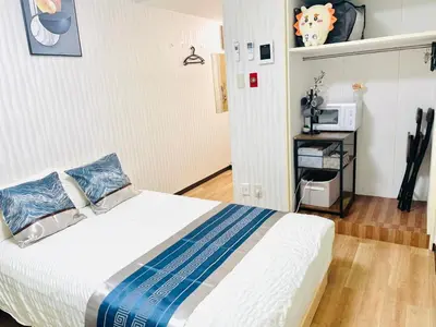 a bedroom with a bed and a microwave at S1-\u65b0\u5bbf\u6700\u4e2d\u5fc3 \u6771\u65b0\u5bbf\u99c54\u5206-Shinjuku center 4 mins to ST Max 4P \u76f4\u8fbe\u65b0\u5bbf \u6e0b\u8c37 \u8868\u53c2\u9053 \u6c60\u888b \u4e0a\u91ce \u4ee3\u4ee3\u6728 \u9280\u5ea7 \u539f\u5bbf in Tokyo
