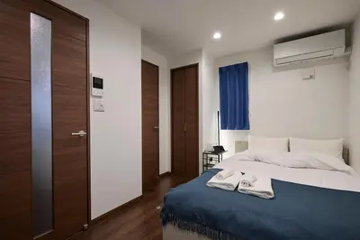 a bedroom with a bed with two towels on it at LIFE TOWN Yotsugi in Tokyo