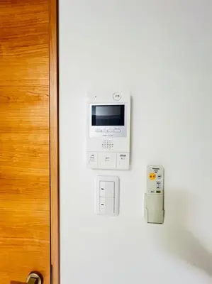 an electronic device on a wall next to a door at incense\u4e0a\u91ce\u6839\u5cb82\uff26 in Tokyo