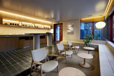 a lobby with chairs and tables and a counter at Minn Asakusa Kuramae North in Tokyo
