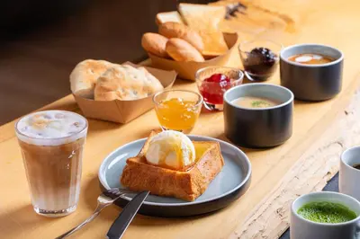 a wooden table with a plate of bread and drinks at Minn Asakusa Kuramae North in Tokyo