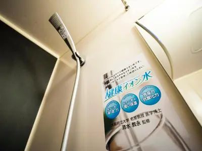 a toothbrush holder with a sign on a wall at SUPER HOTEL Tokyo Akabane Station Higashiguchi Ichibangai in Tokyo