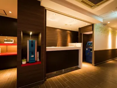 a bathroom with a blue dispenser on a wall at SUPER HOTEL Tokyo Akabane Station Higashiguchi Ichibangai in Tokyo