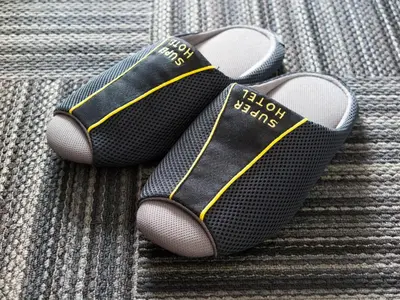 a pair of flip flops sitting on a couch at SUPER HOTEL Tokyo Akabane Station Higashiguchi Ichibangai in Tokyo