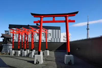 a row of red torii gates in front of a building at Minn Asakusa Kuramae Station in Tokyo