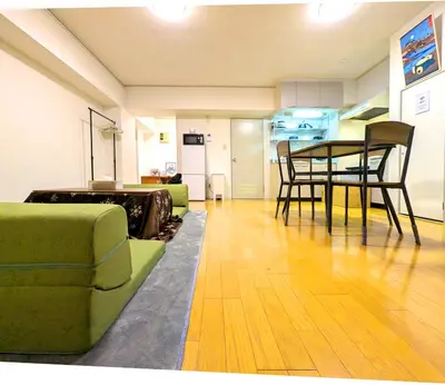 a living room with a green couch and a table at Asakusa Tokyo T'sRoom in Tokyo