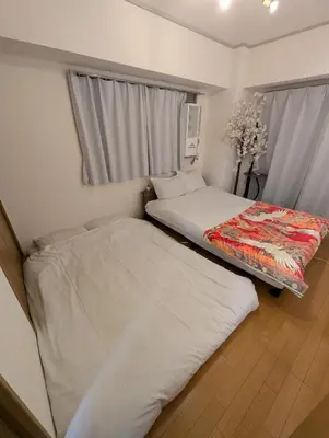 a bedroom with two beds and a window at Asakusa Tokyo T'sRoom in Tokyo