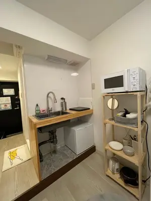 a small kitchen with a sink and a microwave at PLAZA SINJUKU Cozy Mansion #2 in Tokyo