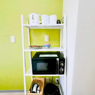 a microwave on a shelf in a room at PLAZA SINJUKU Cozy Mansion #2 in Tokyo