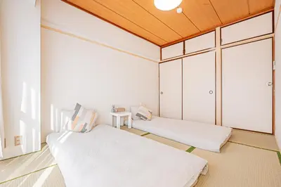 two beds in a room with a wooden ceiling at \u65b0\u5bbf\u6b4c\u821e\u4f0e\u753a\u5f92\u6b65\u4e09\u5206\u9418\u4e09\u623f\u4e00\u5ef3\u8fd1\u9130\u4f0a\u52e2\u4e39 in Tokyo