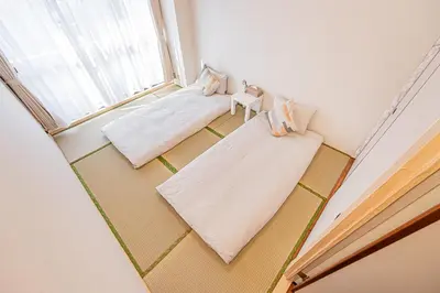 a room with two beds and a window at \u65b0\u5bbf\u6b4c\u821e\u4f0e\u753a\u5f92\u6b65\u4e09\u5206\u9418\u4e09\u623f\u4e00\u5ef3\u8fd1\u9130\u4f0a\u52e2\u4e39 in Tokyo