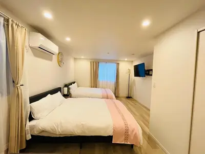 a hotel room with two beds and a television at Year-end promotion Free Wi-Fi spacious and bright Closs Ueno 1min to Minowa Sta Wide Room Max 4People in Tokyo