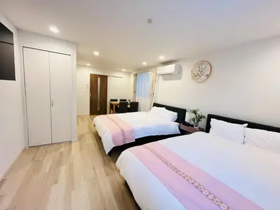 a hotel room with two beds and a table at Year-end promotion Free Wi-Fi spacious and bright Closs Ueno 1min to Minowa Sta Wide Room Max 4People in Tokyo