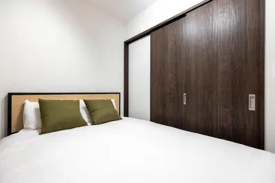 a bedroom with a large bed with a wooden door at The Parkcross\u4e21\u56fd\u7dd1 in Tokyo