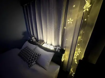 a bedroom with a bed with a window with lights at \u30a2\u30f3\u30c9\u30b9\u30c6\u30a4\u4e2d\u91ce5\u4e01\u76ee102 in Tokyo