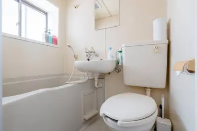 a white bathroom with a toilet and a sink at \u30a2\u30f3\u30c9\u30b9\u30c6\u30a4\u4e2d\u91ce5\u4e01\u76ee102 in Tokyo