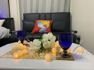 a table with two blue wine glasses and flowers on it at \u30a2\u30f3\u30c9\u30b9\u30c6\u30a4\u4e2d\u91ce5\u4e01\u76ee102 in Tokyo