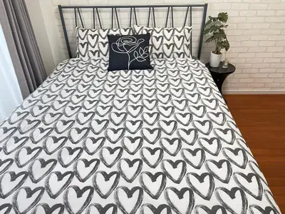 a bed with a black and white bedspread and pillows at S5 Shibuya center-350m from Shibuya St ation in Tokyo